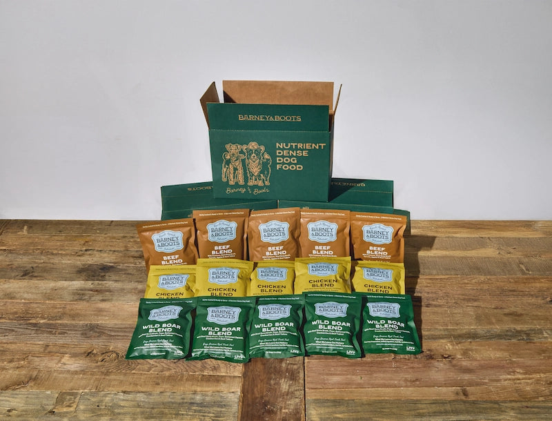 Collection of Barnaby Boots pet food packages on a wooden surface with a white background